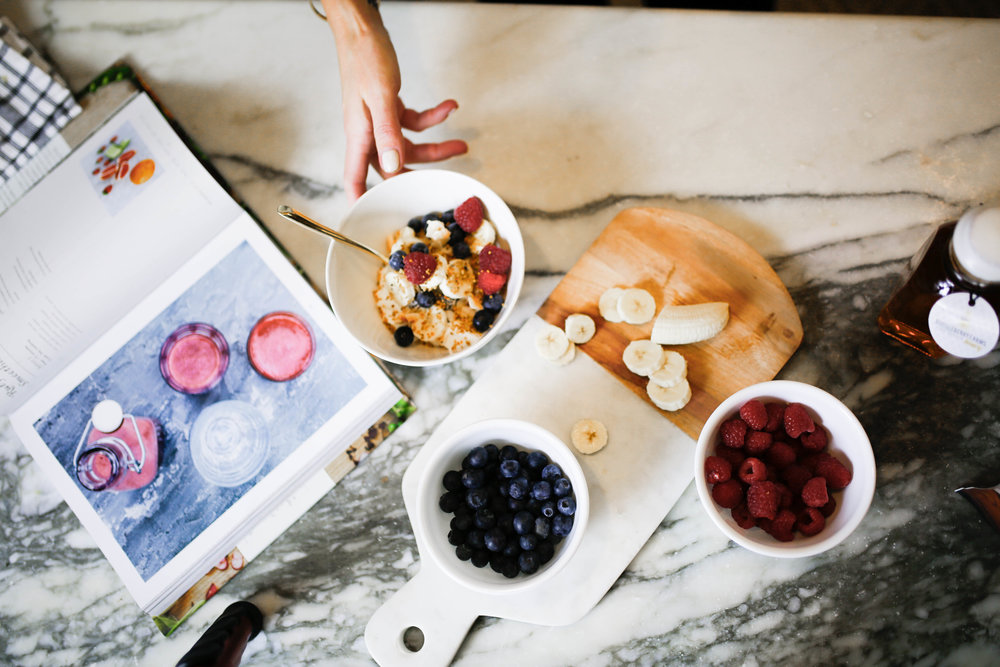  making a healthy breakfast with berries on a marble cutting board 